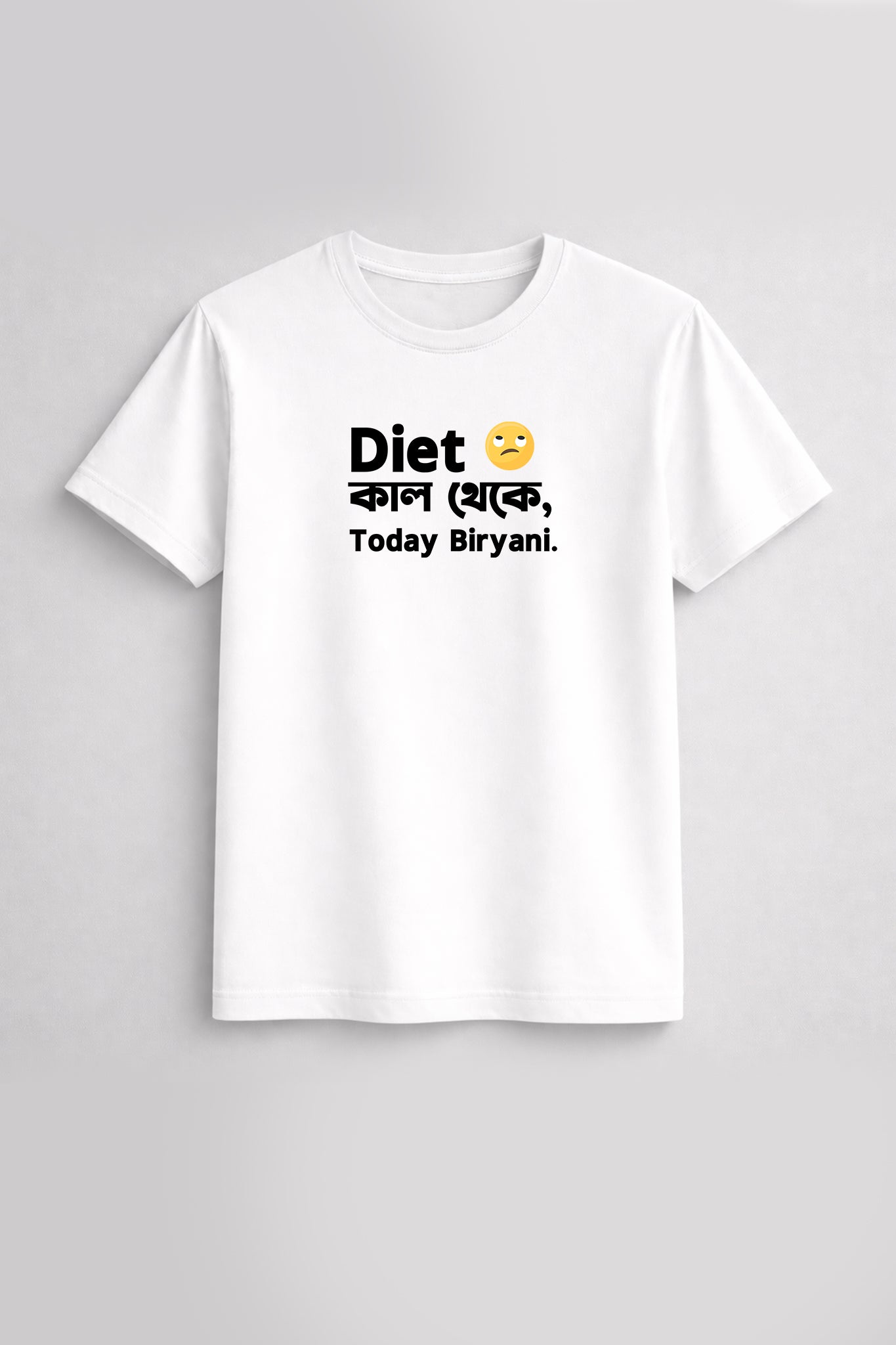White t-shirt with text and emoji on a gray background