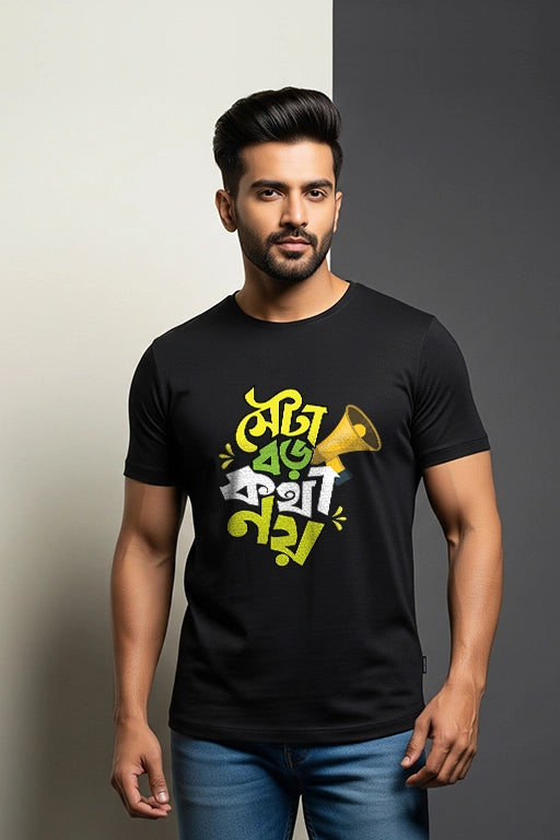 Man wearing a black t-shirt with colorful text and graphics on a gray background