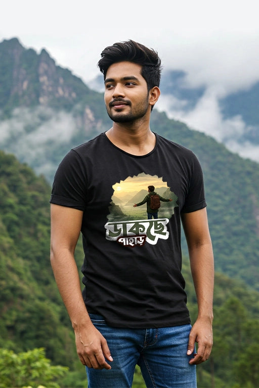Man wearing a black t-shirt with a graphic design in front of a mountainous landscape