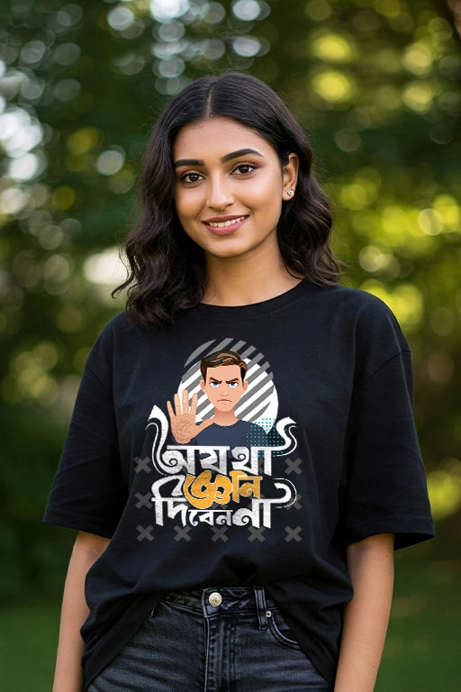Woman wearing a black t-shirt with a graphic design and text, standing outdoors with greenery in the background.