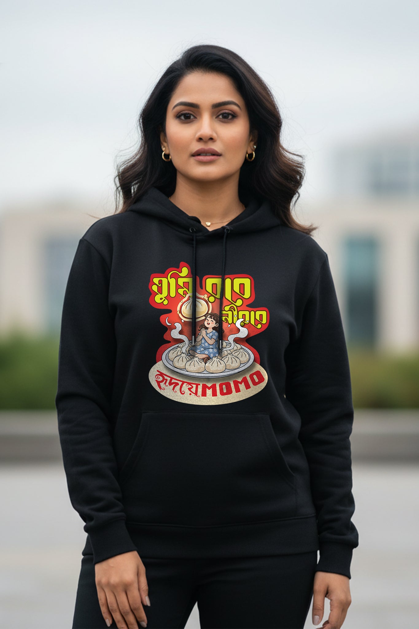 Front view of a woman wearing the black Momo hoodie by KRAZYKIND, showcasing the casual, comfortable design and logo details.