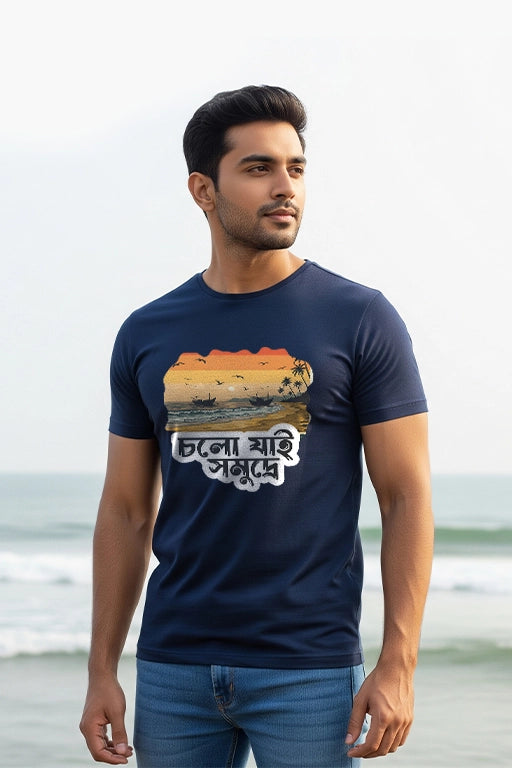 Man wearing a navy blue t-shirt with a graphic design on a beach