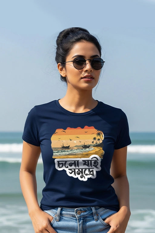 Woman wearing a navy blue t-shirt with a graphic design on a beach