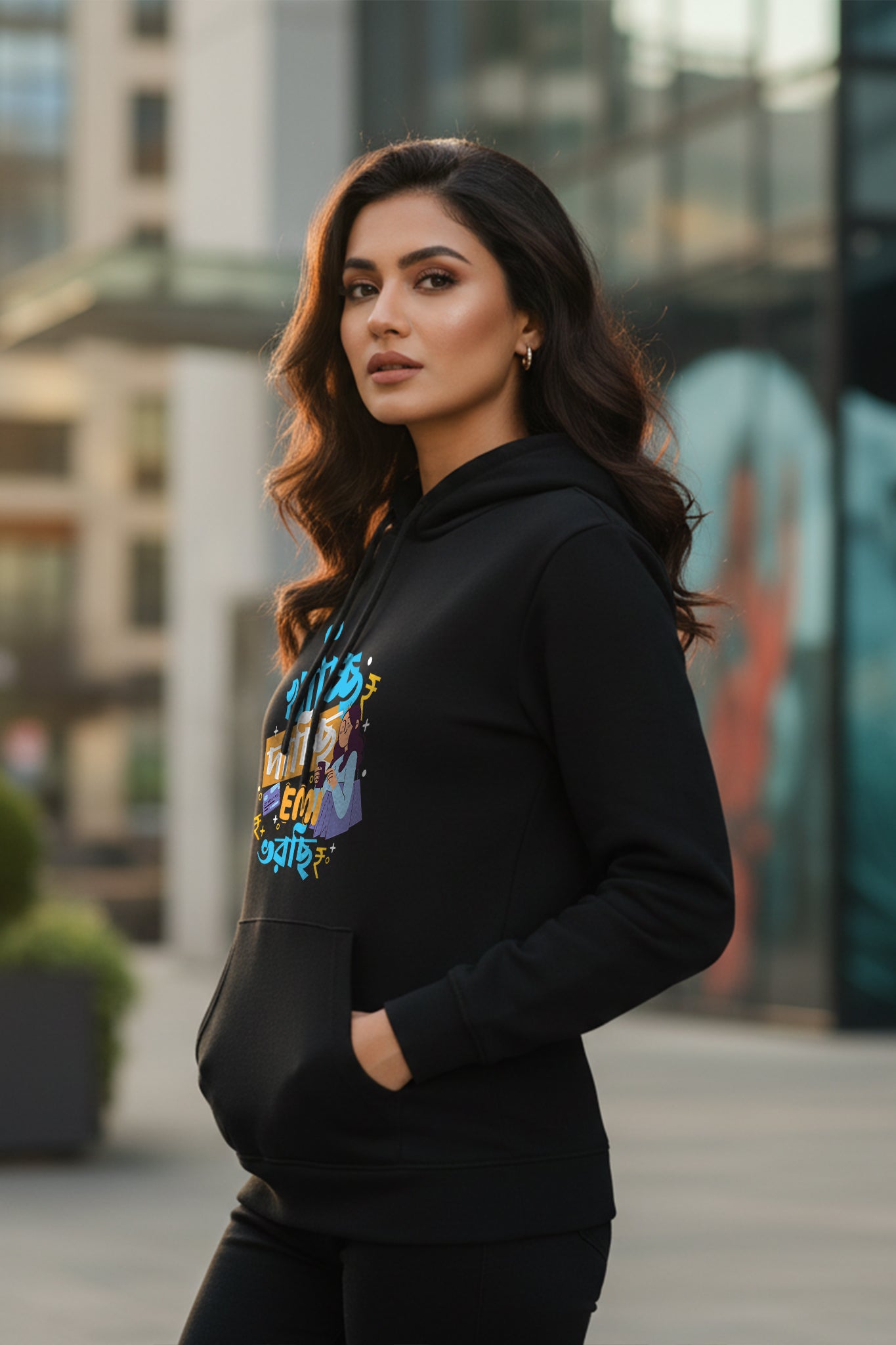 Woman wearing the EMI Dichhi Black Hoodie by KRAZYKIND, shown from the side view, showcasing the comfortable fit and stylish design.