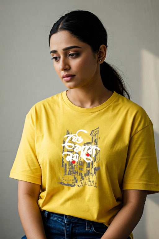 Woman wearing a yellow t-shirt with a graphic design against a plain background